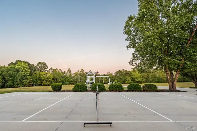 Sport court with a net and a playset beyond at 1351 Country Estates Drive, Lowry VA