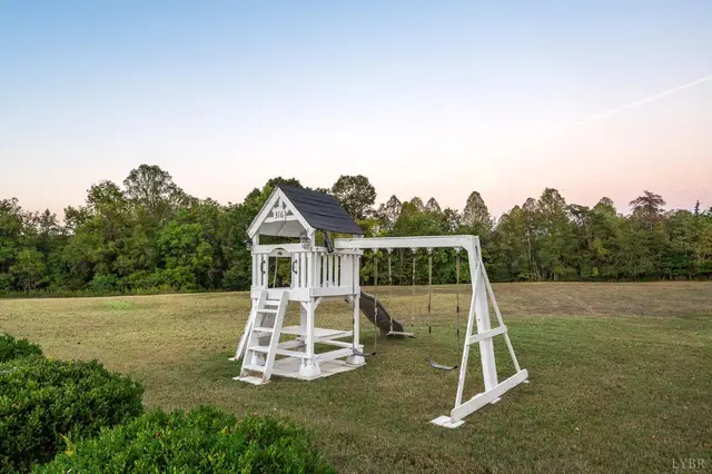 Backyard playset with a slide and swings on an open lawn at 1351 Country Estates Drive, Lowry VA