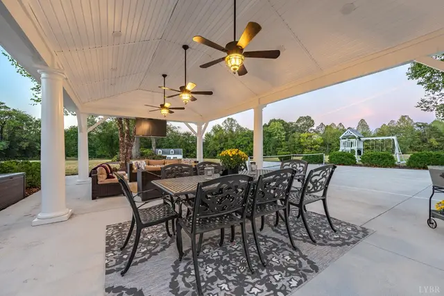 Covered patio with an outdoor dining table and ceiling fans at 1351 Country Estates Drive, Lowry VA