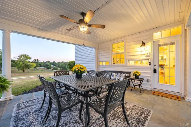 Back porch with a flagstone floor, dining table and ceiling fan at 1351 Country Estates Drive, Lowry VA