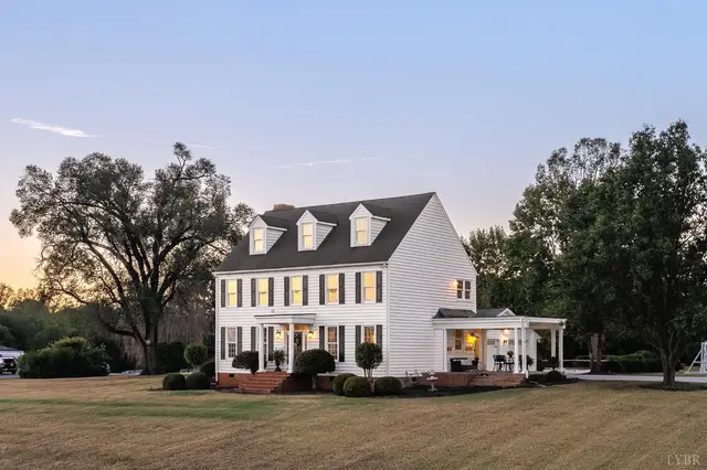 Front of the house with a side porch and dormers at dusk at 1351 Country Estates Drive, Lowry VA