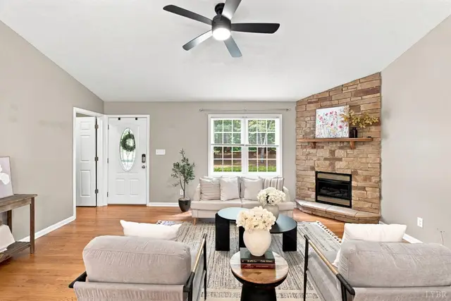 Living room with a stone corner fireplace and a ceiling fan at 1378 Greenhouse Road, Rustburg VA