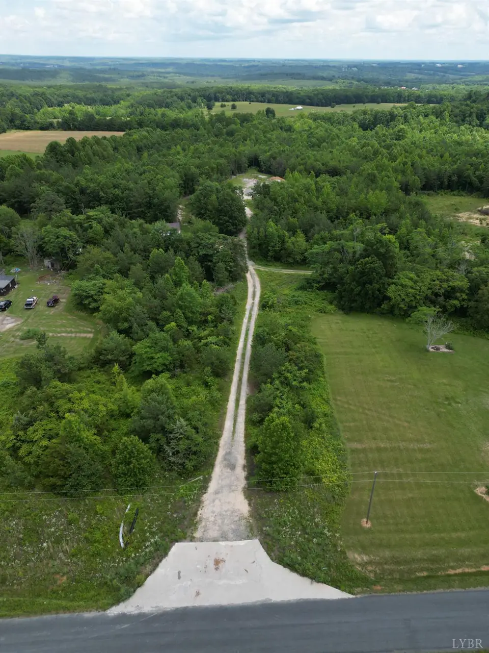 Aerial view of a gravel drive leading from the road through woods and fields at 150 Mt. Zion Road, Phenix VA