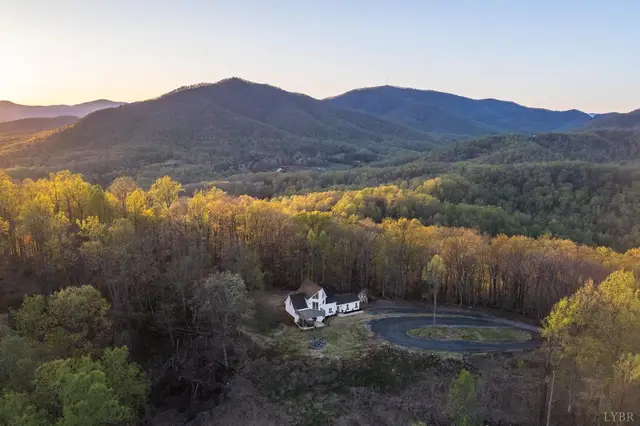 Aerial view of the house and circular driveway with mountain views at 1520 Grassy Mountain Lane, Forest VA