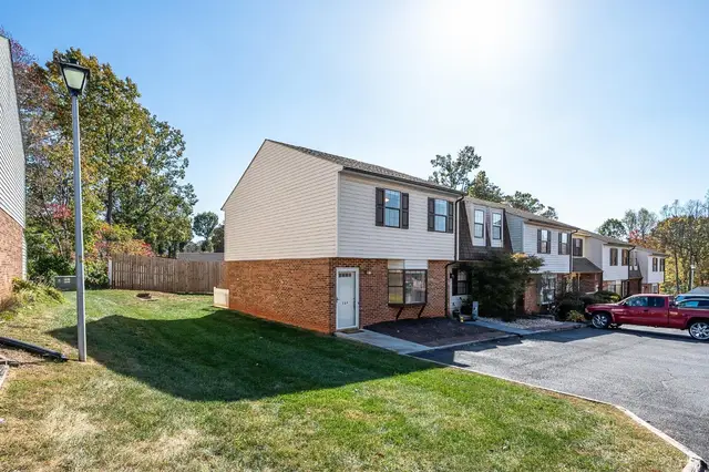 Townhouse row with a brick lower level and a parking lot at 164 Cape Charles Sq, Lynchburg VA