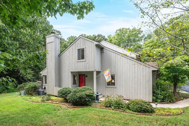 Front of the house with vertical gray siding, a chimney and a red front door at 174 Sunset Ridge Road, Forest VA
