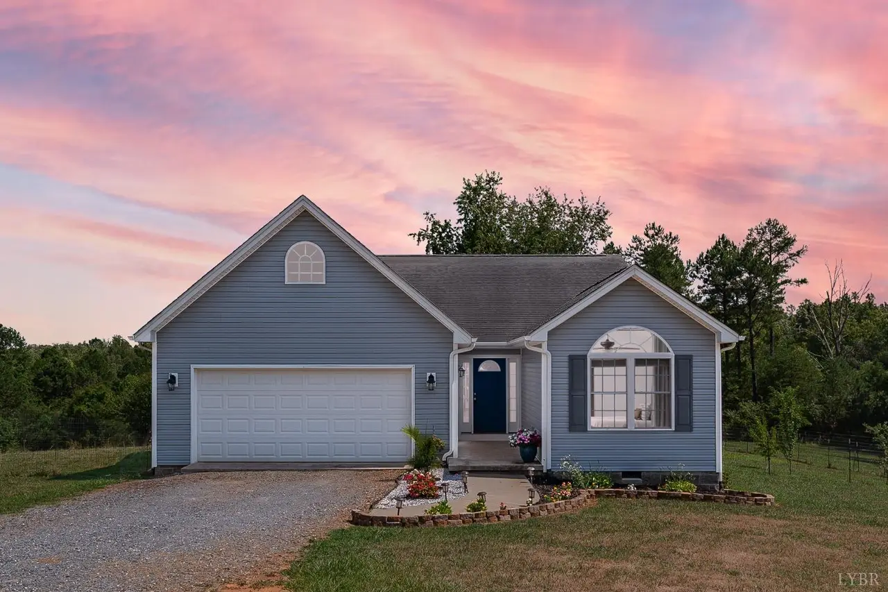 Front of the house with blue siding and a two-car garage at sunset at 194 Oak Spring Lane, Madison Heights VA