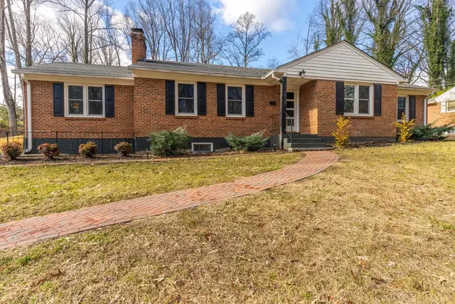 Front of the house, brick ranch with black shutters and a brick walkway at 2019 Indian Hill Rd Road, Lynchburg VA