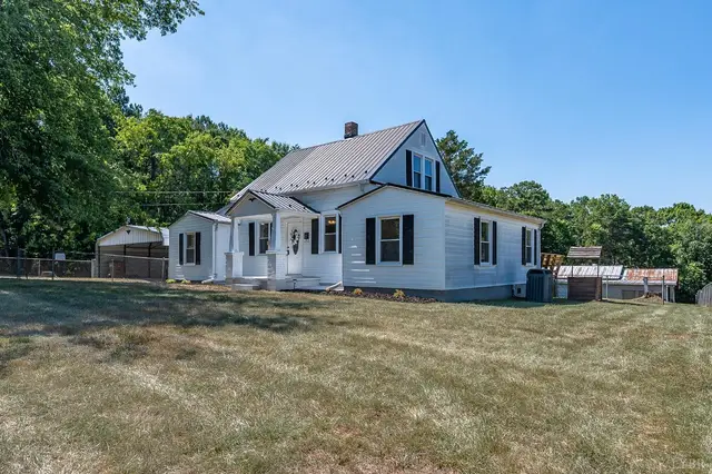 Side view of the white house with a metal roof and a large lawn at 202 Longview Road, Hurt VA