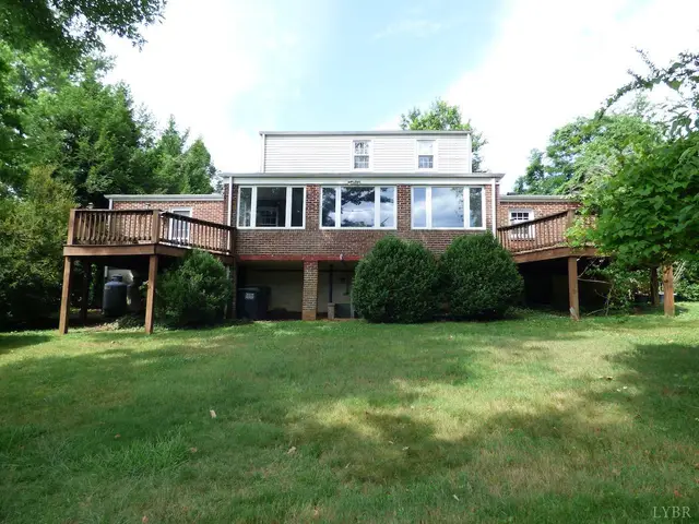 Back of the house with a raised wooden deck and a sunroom at 207 Garland Avenue, Amherst VA
