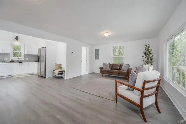 Living room with gray floors, open to the white kitchen at 223 7th Street, Madison Heights VA