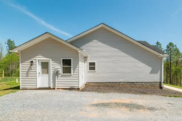 Back of the house with white siding and a gravel driveway at 2292 Wheeler Road, Lynchburg VA