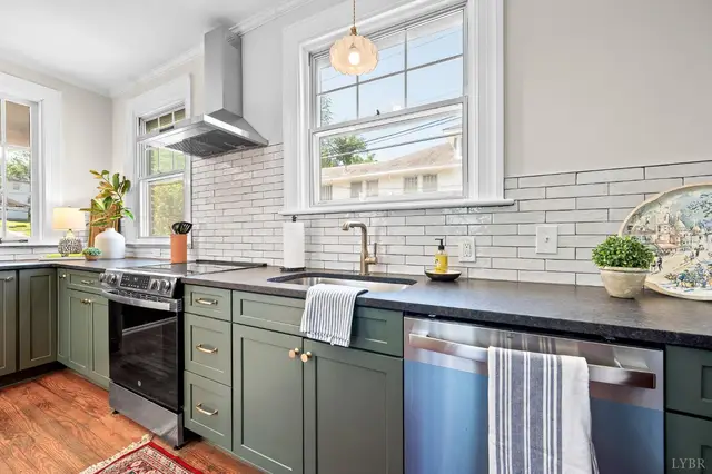 Kitchen with green cabinets, white subway tile and a range hood at 240 Warwick Lane, Lynchburg VA