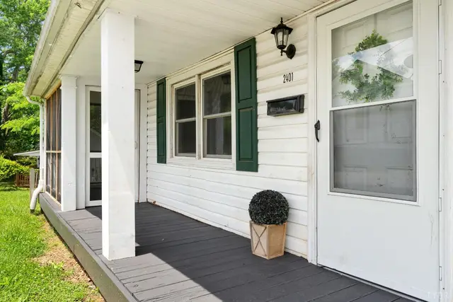 Front porch with white columns, green shutters and a gray floor at 2401 Otey Street, Lynchburg VA