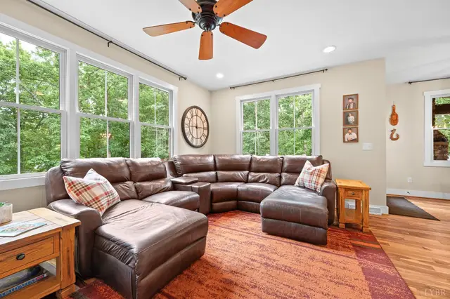 Living room with a leather sectional and large windows at 2842 Chilton Road, Appomattox VA