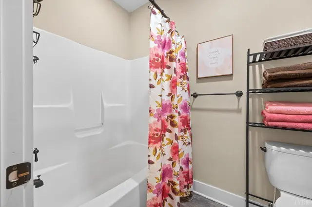 Bathroom with a tub shower and floral curtain at 2842 Chilton Road, Appomattox VA