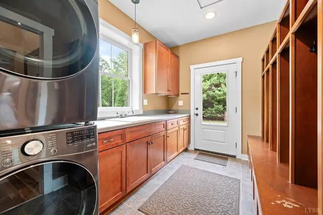 Laundry room with a stacked washer and dryer and built-in lockers at 2842 Chilton Road, Appomattox VA