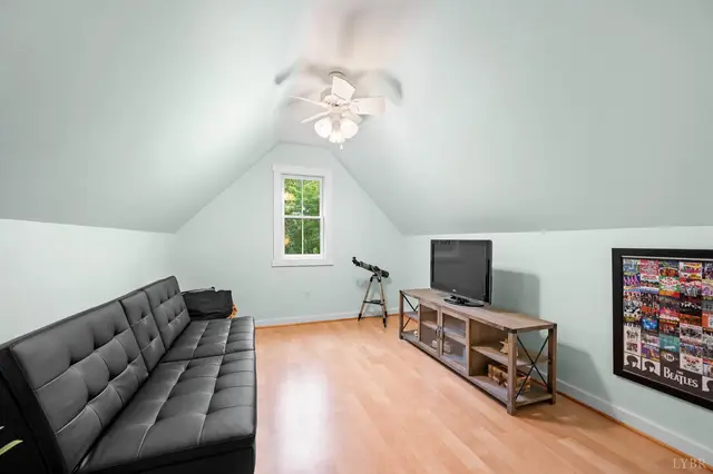 Attic room with a black futon and TV stand at 2842 Chilton Road, Appomattox VA