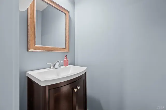 Half bath with a dark vanity and wood framed mirror at 2842 Chilton Road, Appomattox VA