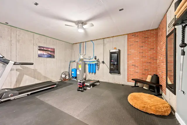 Basement gym with a treadmill and brick accent wall at 2842 Chilton Road, Appomattox VA