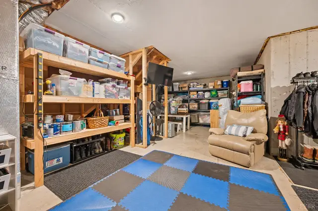 Unfinished basement storage area with wood shelving and foam mats at 2842 Chilton Road, Appomattox VA