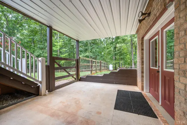 Covered patio with a gate and stairs to the deck at 2842 Chilton Road, Appomattox VA