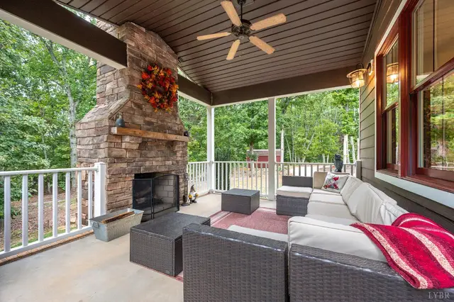 Covered porch with a stone fireplace and wicker seating at 2842 Chilton Road, Appomattox VA