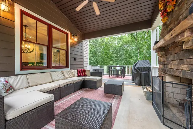 Covered porch with a wicker sectional and a view to the deck at 2842 Chilton Road, Appomattox VA