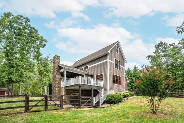 Back of the house with a covered deck and wood fence at 2842 Chilton Road, Appomattox VA