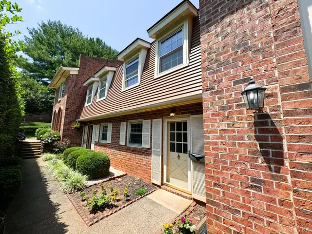 Front of the brick townhouses with dormers and a landscaped walkway at 3101 Link Road # 26, Lynchburg VA