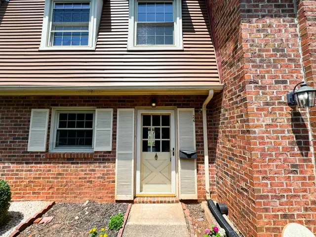 Front entry with a cream door, shutters and brick walls at 3101 Link Road # 26, Lynchburg VA