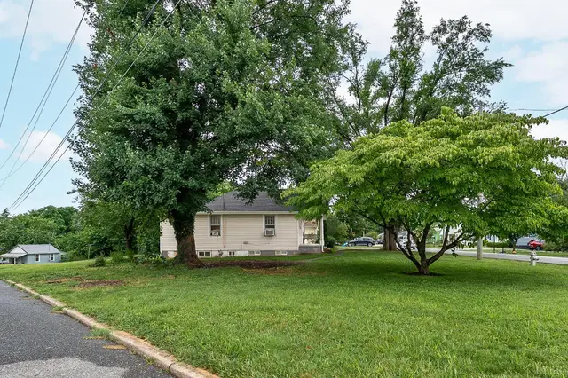 View across a large lawn with shade trees toward the house at 3243 Maryland Avenue, Lynchburg VA
