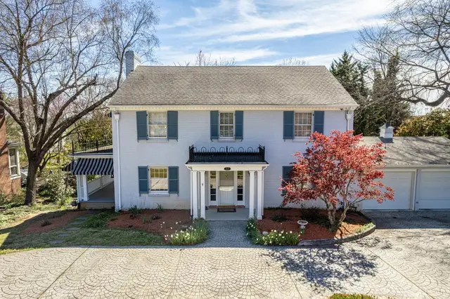 Front of the two-story white brick house with blue shutters at 3405 Rivermont Avenue, Lynchburg VA