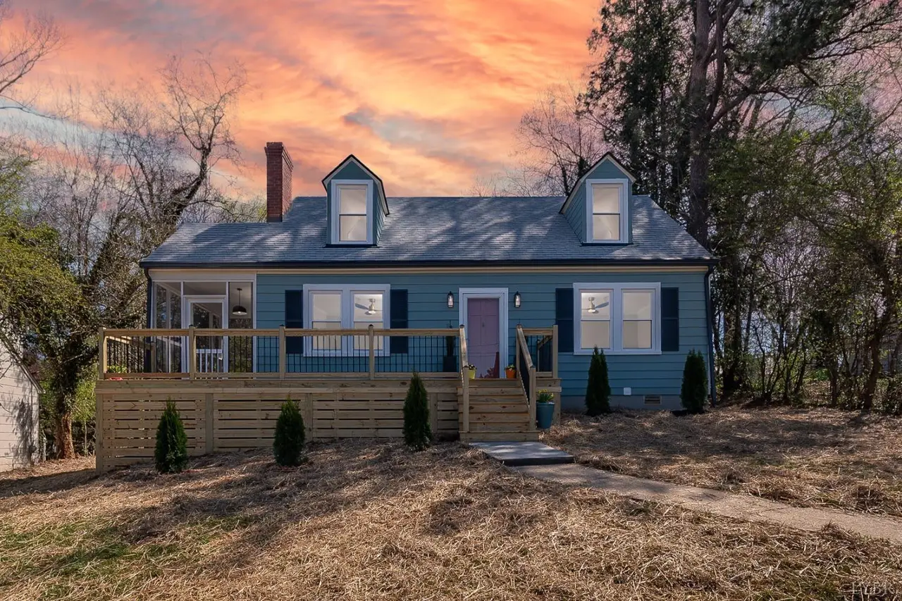 Front of the blue house with dormers and a new wood deck at sunset at 38 Norfolk Avenue, Lynchburg VA