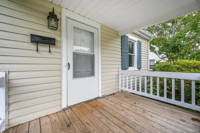 Covered front porch with a wood floor and white railing at 4906 Sycamore Pl, Lynchburg VA