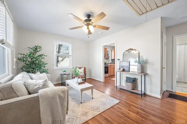 Living room with a beige sofa, ceiling fan and wood floors at 4906 Sycamore Pl, Lynchburg VA
