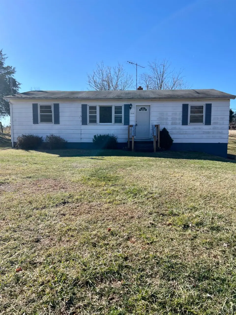 Front of the one-story house with white siding and blue shutters at 519 W E Monitor Road, Amherst VA