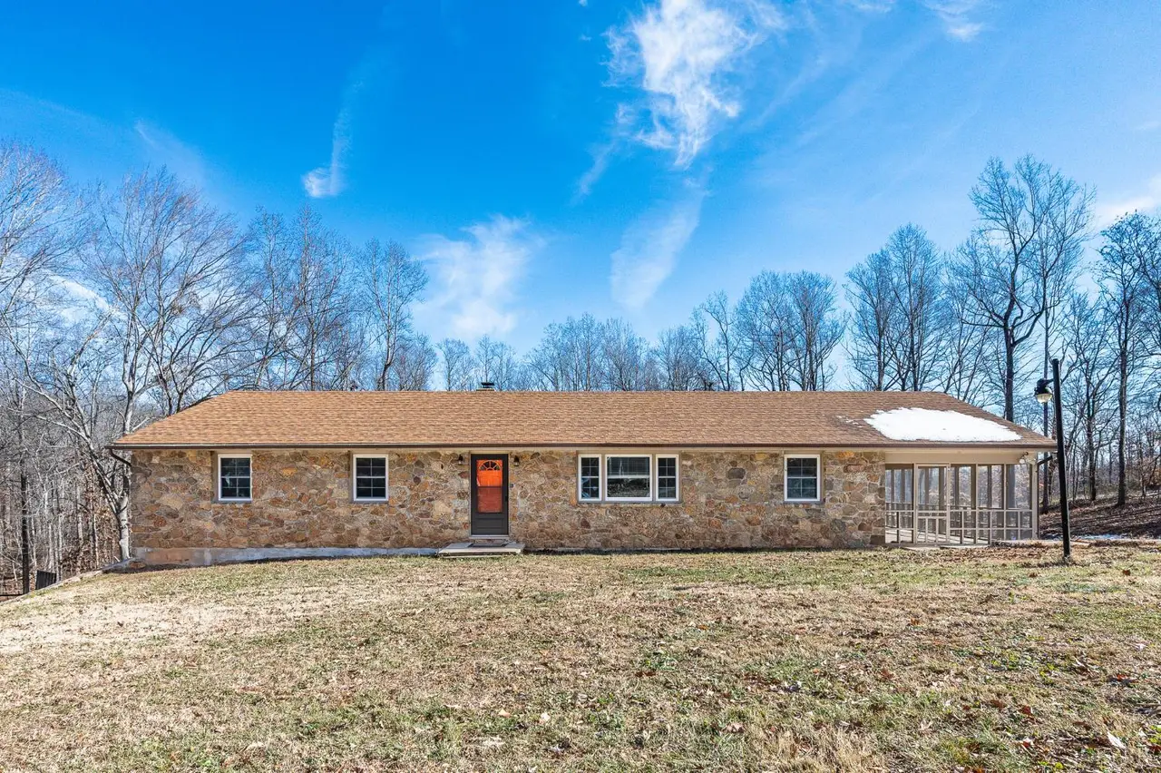 Front of the one-story stone house with a wooded backdrop at 520 Old Trents Ferry Road, Lynchburg VA