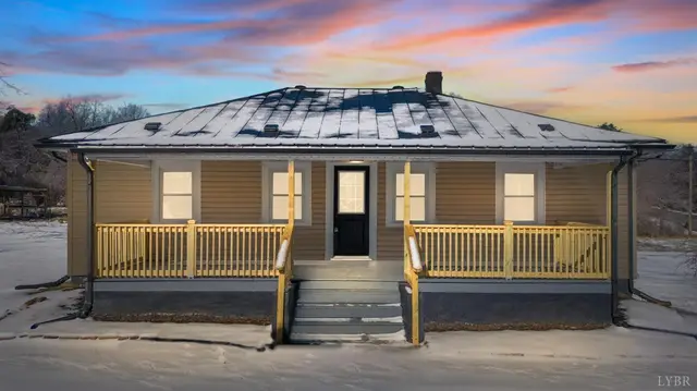 Front of the house with a metal roof and covered porch at sunset at 533 Patterson, Appomattox VA