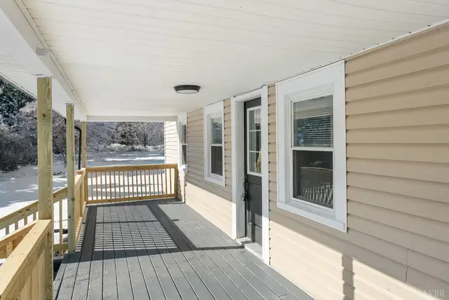 Covered front porch with gray floor boards and new wood railing at 533 Patterson, Appomattox VA