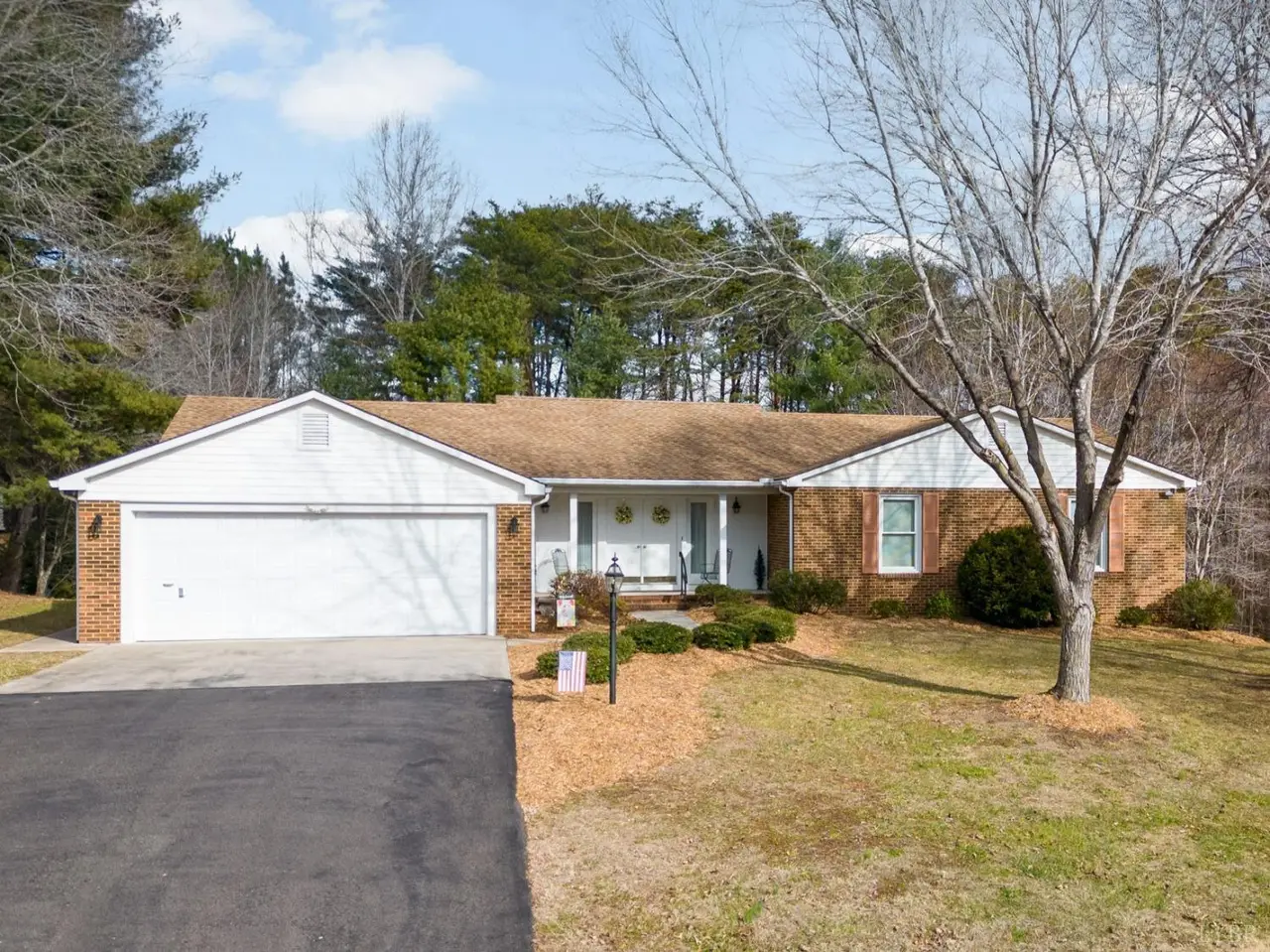 Front of the brick house with an attached garage and paved driveway at 56 Whispering Pine Circle, Altavista VA