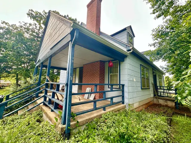 Side view of the house with a blue trimmed porch and brick chimney at 607 Middle Street, Lynchburg VA