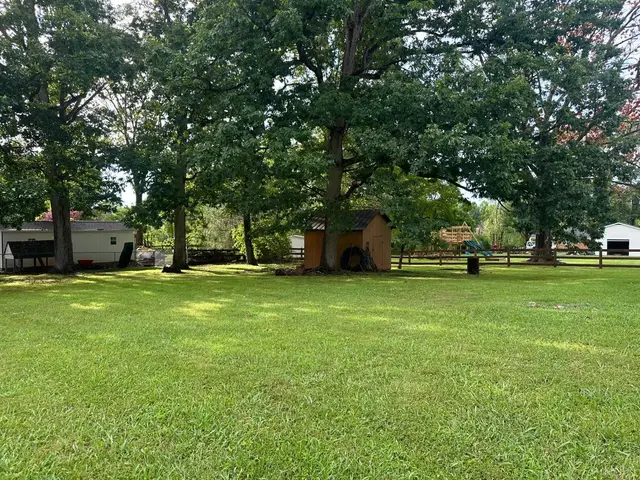 Large grassy yard with mature trees and a small shed at 607 Middle Street, Lynchburg VA