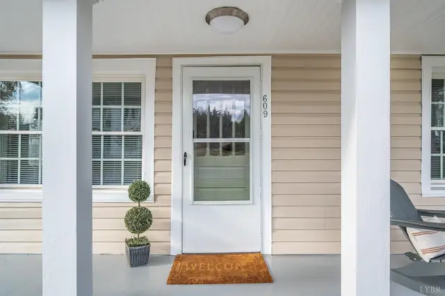 Front door with a storm door under the covered porch at 609 Pine Drive, Lynchburg VA