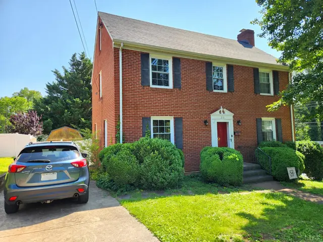 Front of the two-story brick house with a red door and black shutters at 610 Dumas Street, Lynchburg VA