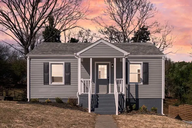 Front of the house with gray siding and a covered entry at sunset at 634 Thomas Road, Lynchburg VA