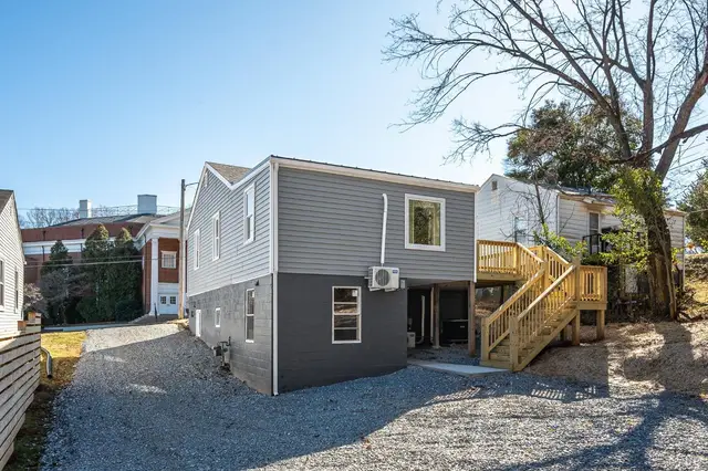 Back of the house with a gravel driveway and new wood stairs at 634 Thomas Road, Lynchburg VA