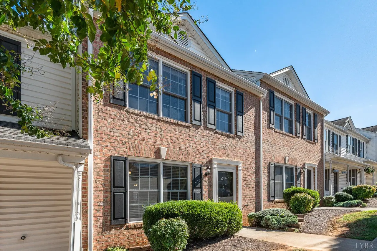 Front of the brick townhouses with black shutters and shrubs at 639 Wyndhurst Drive, Lynchburg VA