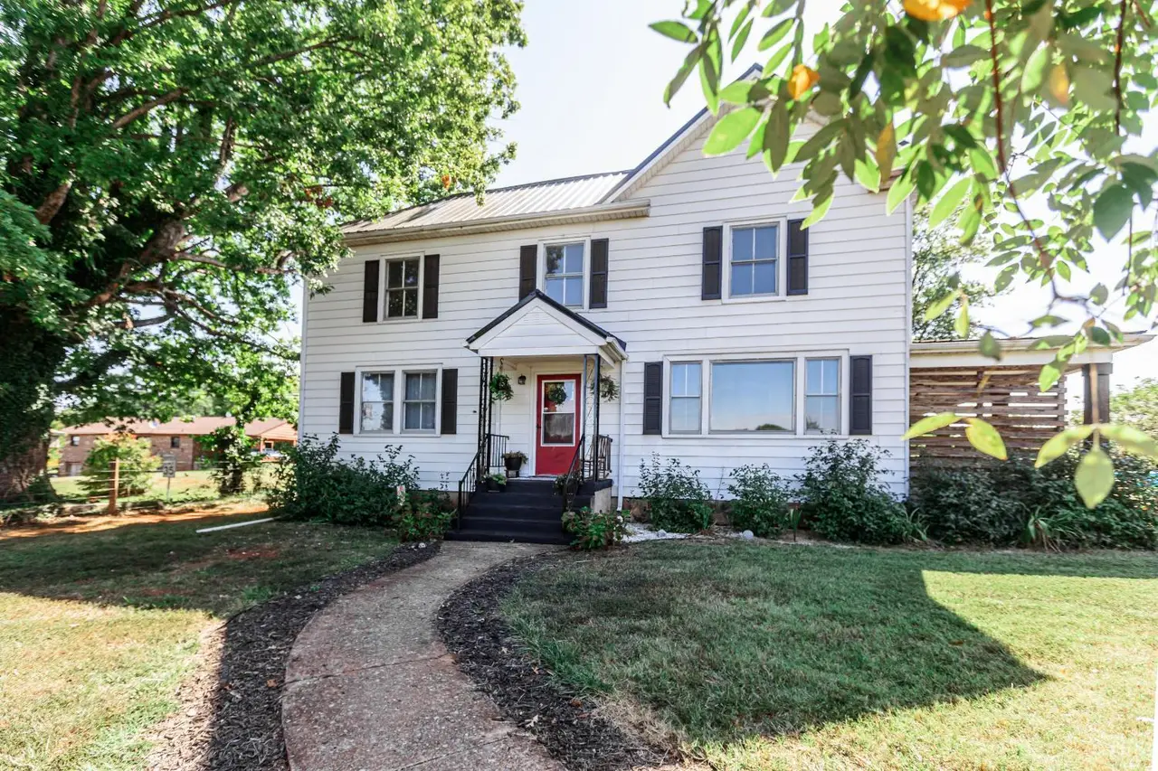 Front of the two-story white house with a curving walkway at 67 Pigeon Run Road, Gladys VA