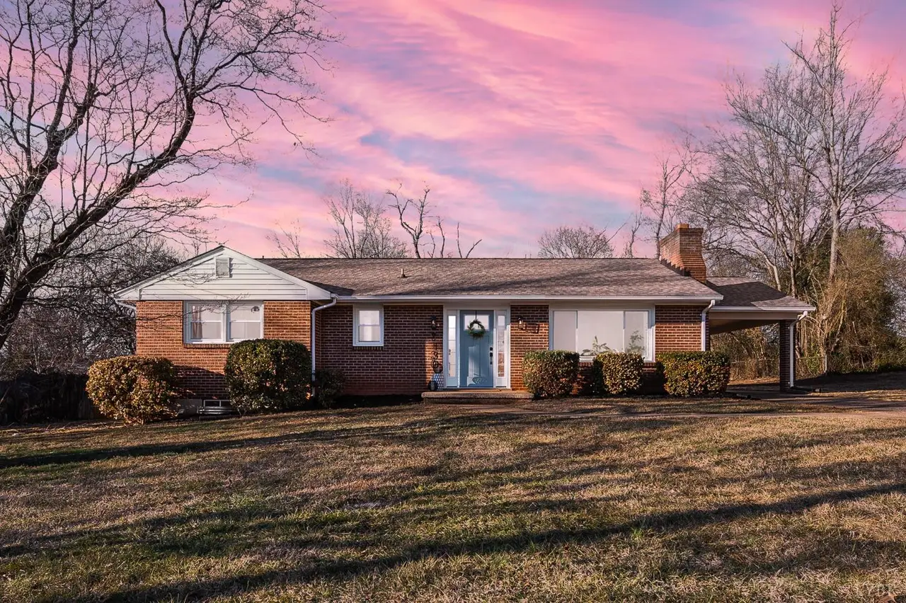 Front of the one-story brick house with a carport at sunset at 7130 Suncrest Drive, Lynchburg VA